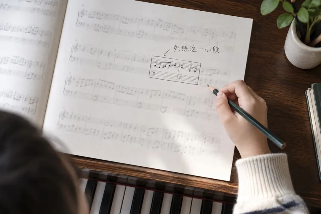 An instructional overhead view of an uncluttered page of staff notation, with just one short passage boxed in pencil and the rest faded. The only text beside it reads “Practice this short passage first,” with no complex explanation of the notes.