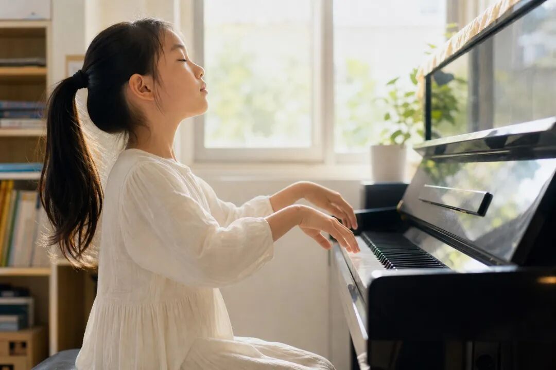 A child lifts their wrist and quietly waits for one beat before the next phrase begins